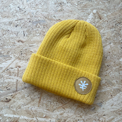 Gul ribbstickad mössa med emblem