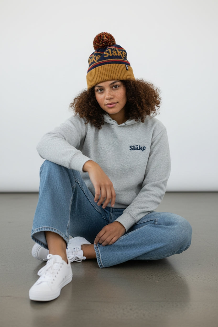 Släke pom mössa i blå, rött och guldtoner