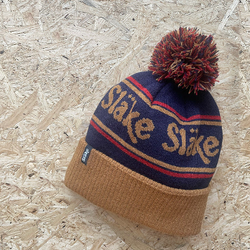 Släke pom mössa i blå, rött och guldtoner